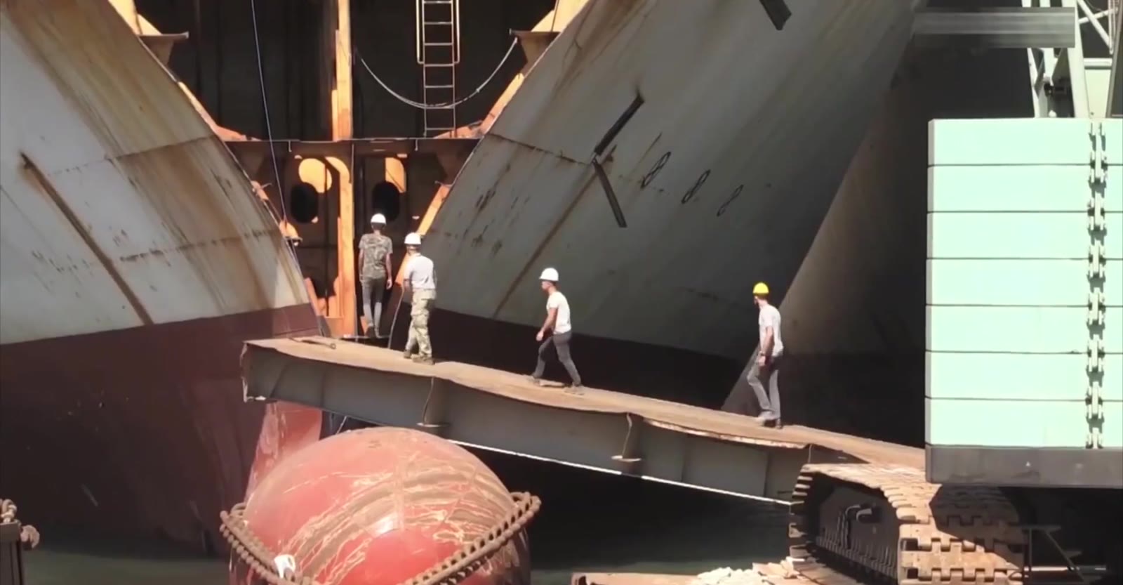Worker cutting a decommissioned vessel with a torch at the ship breaking yard